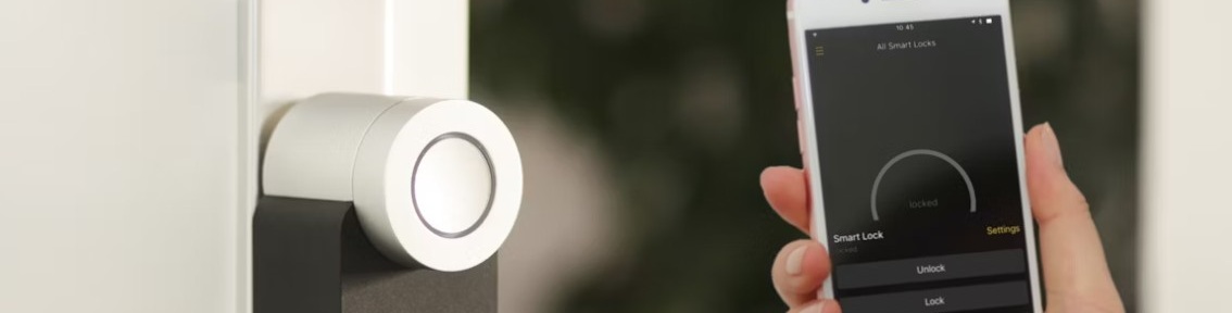 Smart dörrlås på dörr, styrs via app på smartphone som visar låset som låst