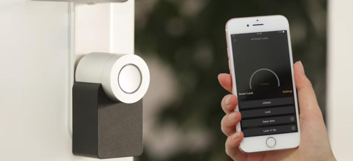 Smart dörrlås på dörr, styrs via app på smartphone som visar låset som låst