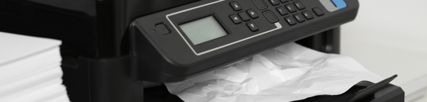 Skrivare med skrynkligt papper som fastnat vid utmatningen.