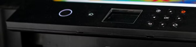 Kontrollpanel på skrivare med ström- och wifi‑indikator.