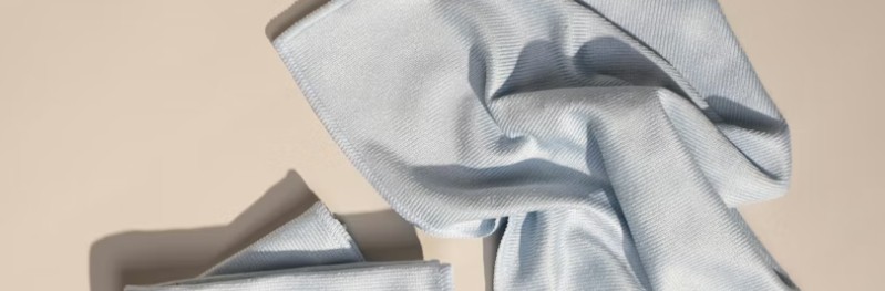 Ljusblå mikrofiberduk i mjukt, vikt mönster på neutral bakgrund.