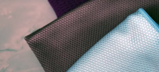 Närbild på mikrofiberdukar i olika färger med texturerad yta.